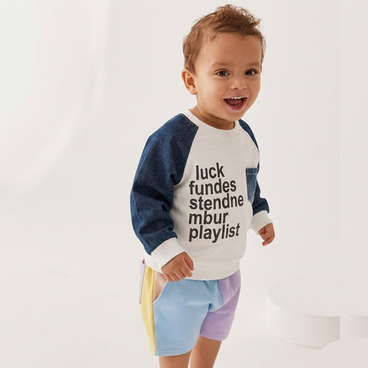 سترة أطفال عصرية بيضاء بأكمام من قماش الجينز الأزرق وطبعة نصية مميزة